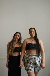 Two models wearing asymmetrical black bralette tops in Victoria BC